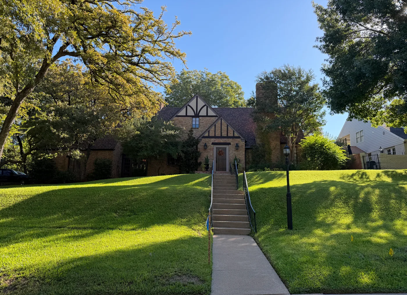 Brick Tudor-style home on a sloped lawn in Crestwood, Fort Worth, where Top Gun Insulation completed an attic insulation retrofit