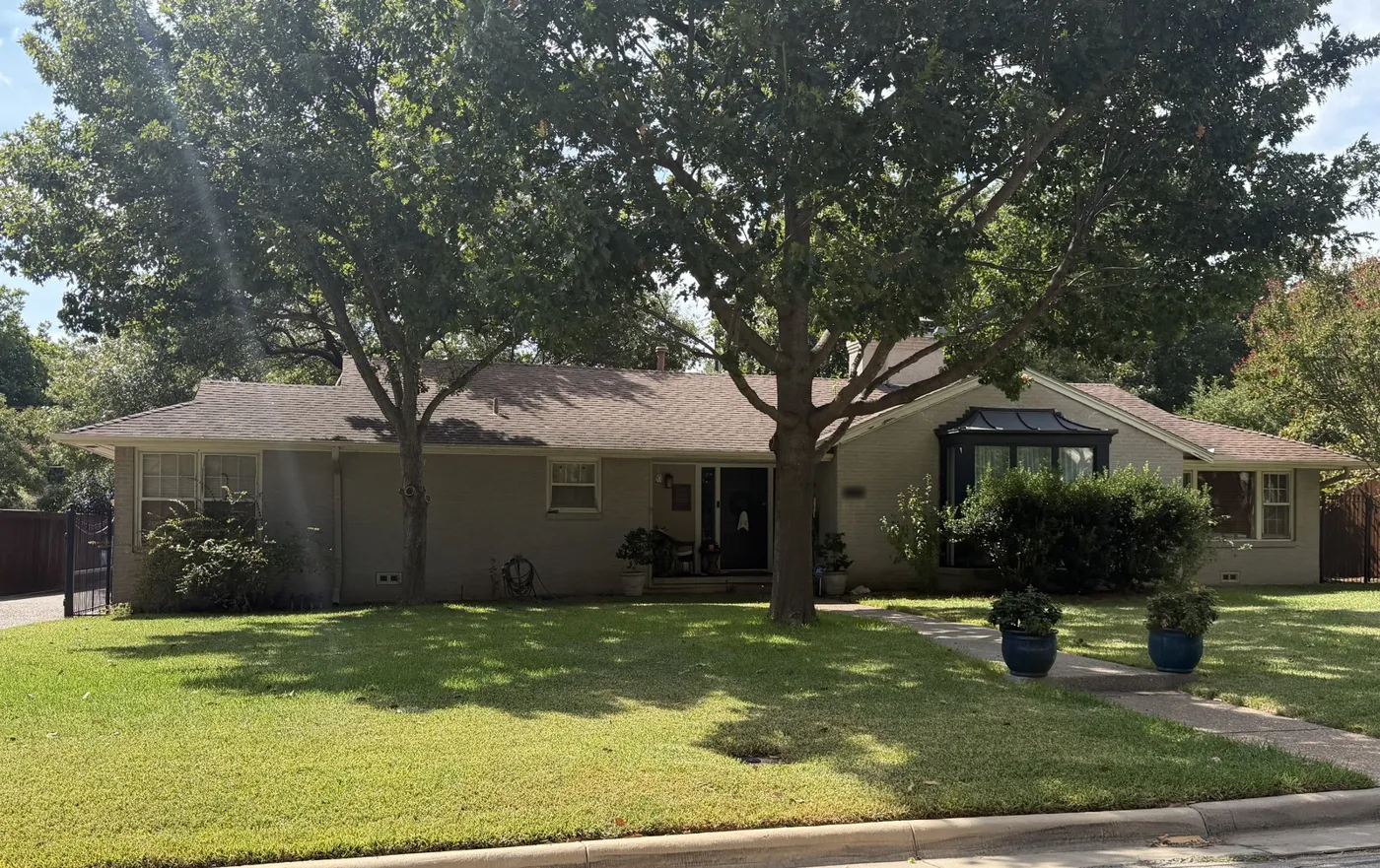 Single-story home under a large oak in Monticello, Fort Worth, after an attic insulation retrofit