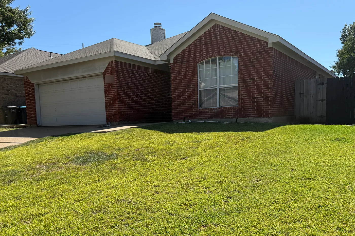 Single-story red brick home with a two-car garage in The Ranches, Fort Worth, with a completed attic insulation retrofit